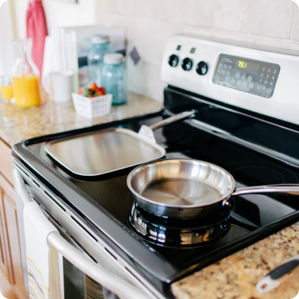 a stainless steel pan on a stove, showcasing cookware in use.